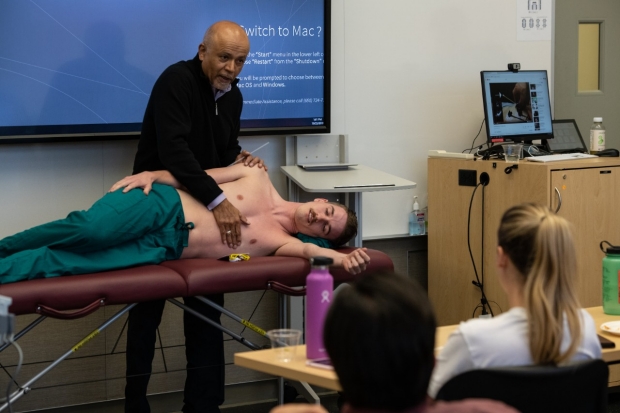 Abraham Verghese demonstrates physical exam at Stanford25 past event